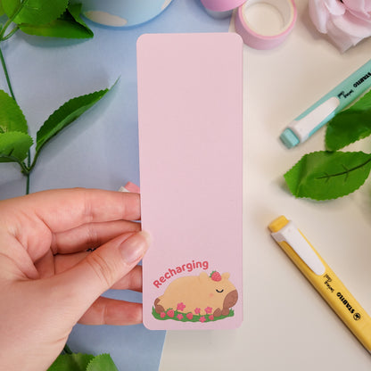 Cute sleeping capybara bookmark featuring the text "Recharging"