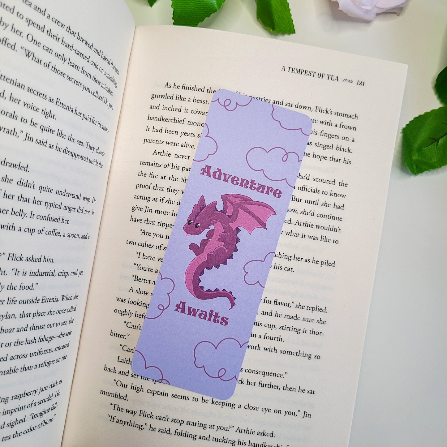 Cute purple dragron bookmark featuring clouds int he background and the text "Adventure Awaits"