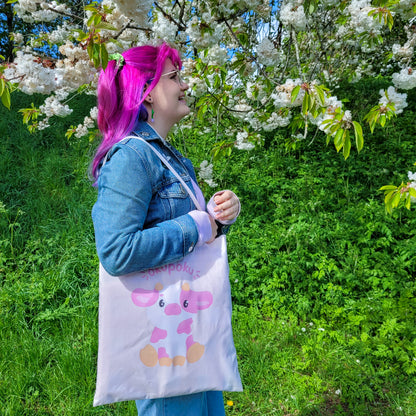 Light pink tote bag featuring an adorable pink cow design and the text okupoku