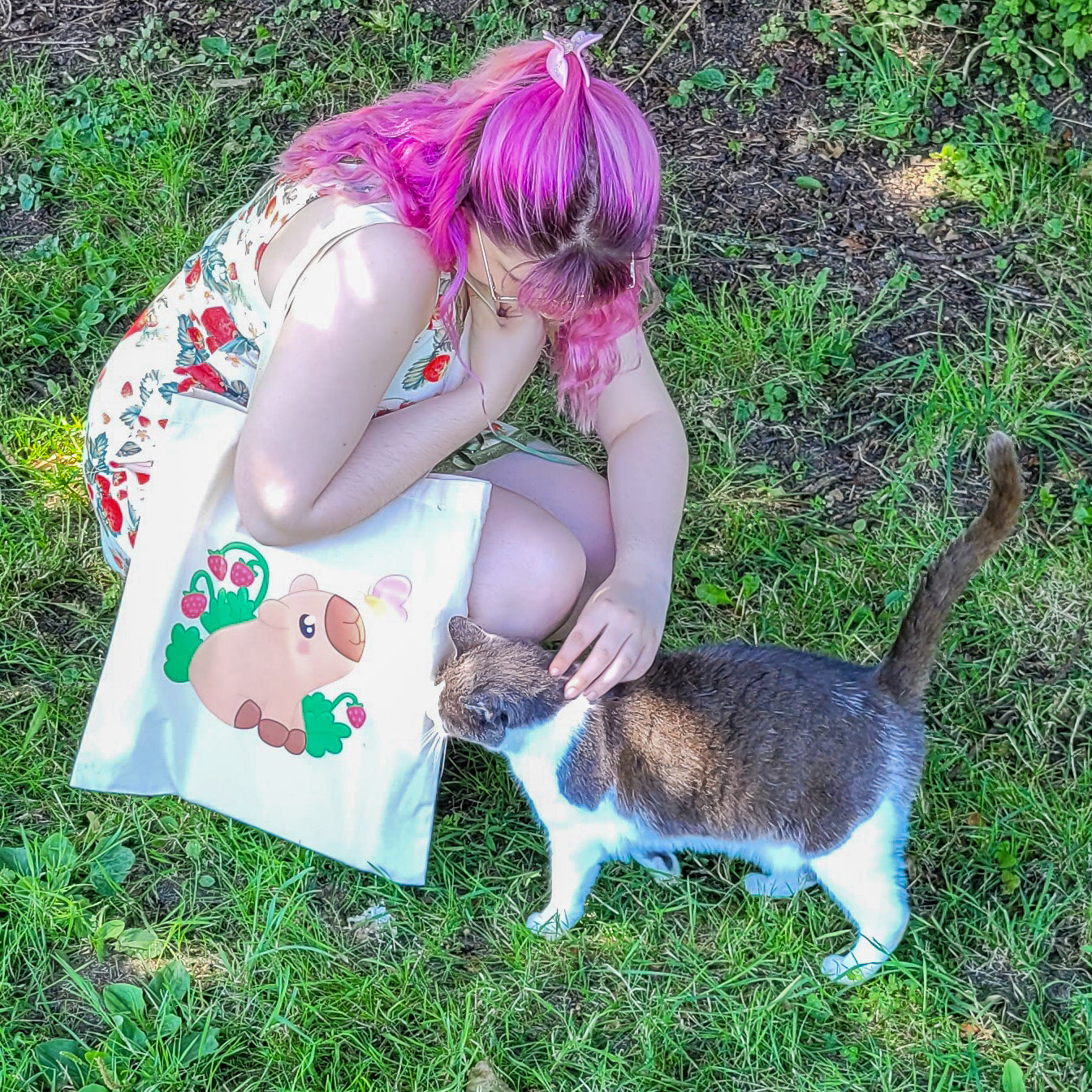 Natural colour tote bag featuring a cute capybara sitting with strawberries and a butterfly