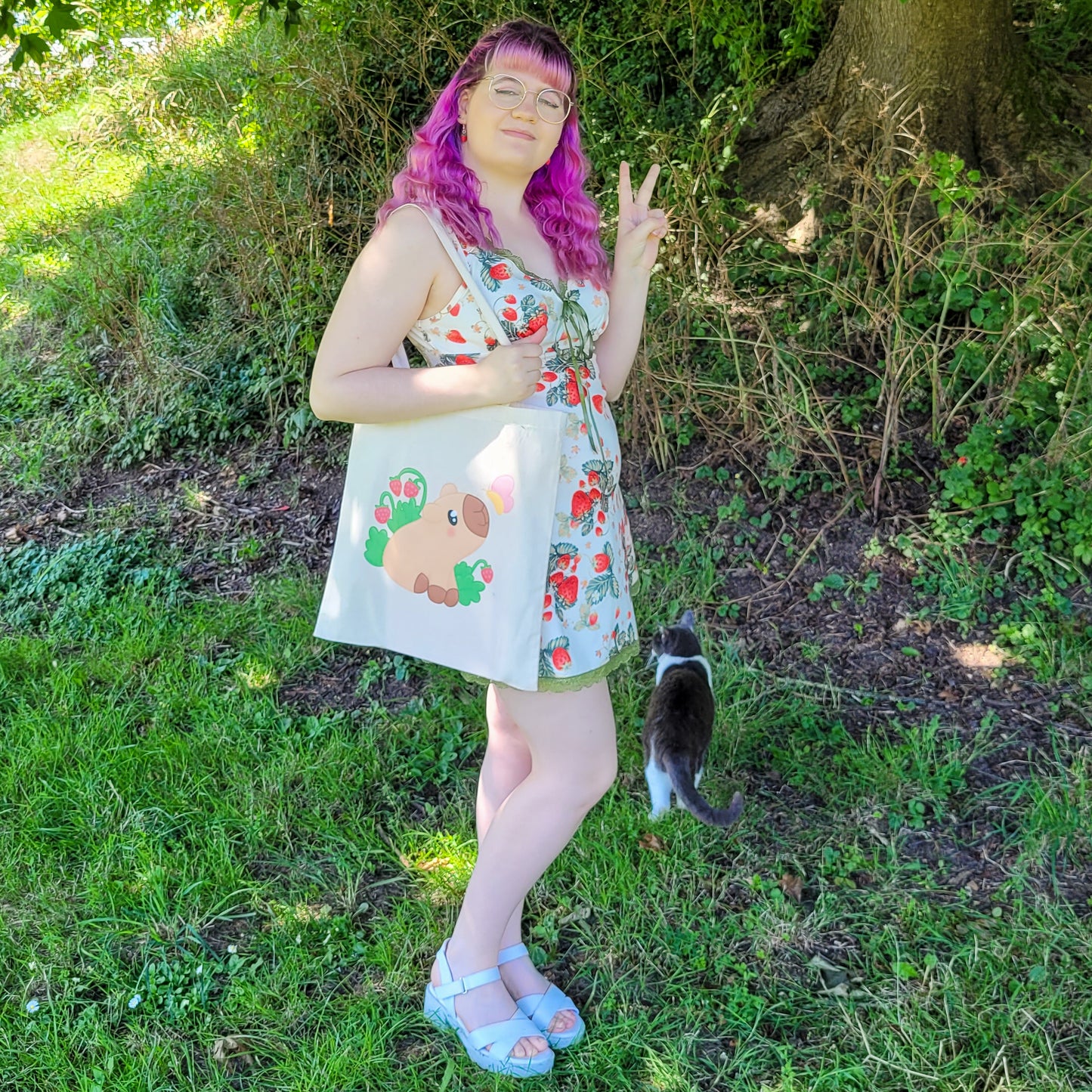 Natural colour tote bag featuring a cute capybara sitting with strawberries and a butterfly