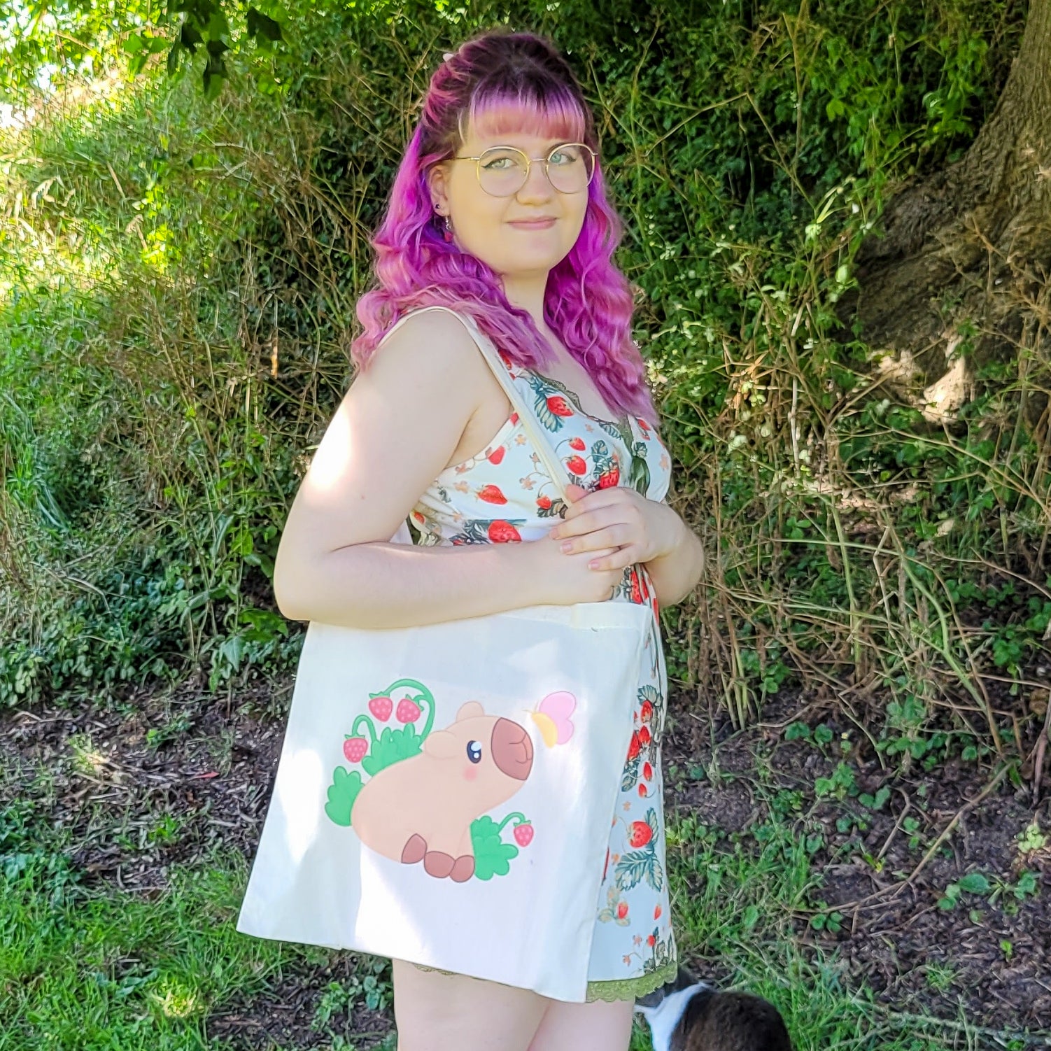 Natural colour tote bag featuring a cute capybara sitting with strawberries and a butterfly