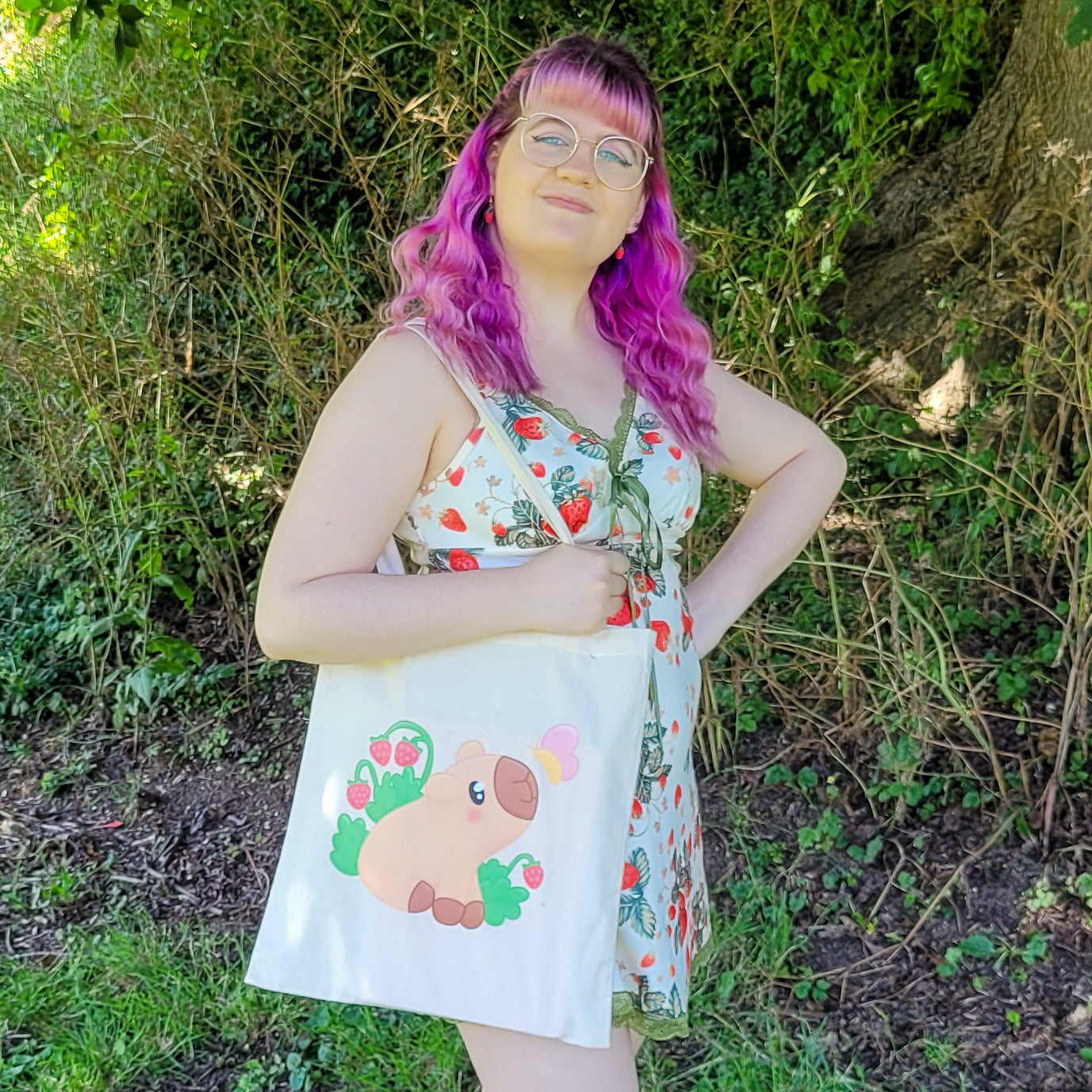 Natural colour tote bag featuring a cute capybara sitting with strawberries and a butterfly