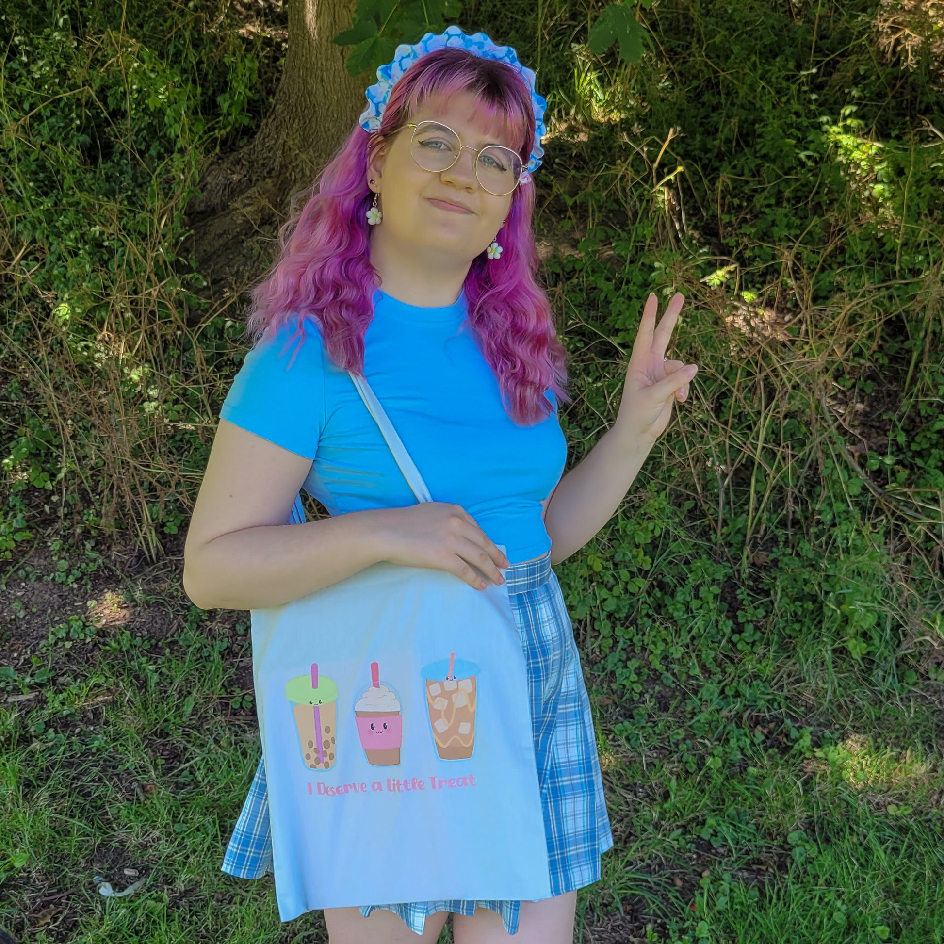 Light blue colour tote bag featuring a design of a bubble tea, frappucino and an iced latte with the text "I deserve a little treat"