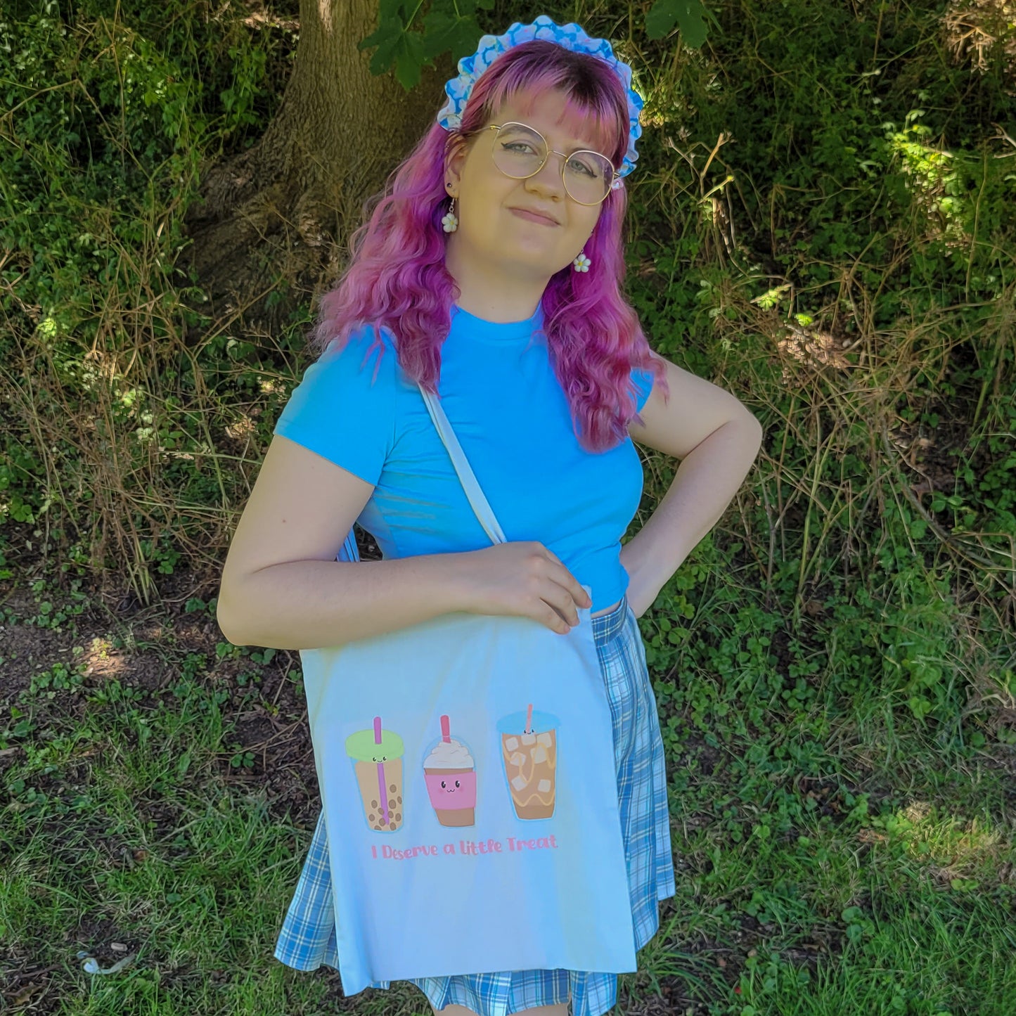 Light blue colour tote bag featuring a design of a bubble tea, frappucino and an iced latte with the text "I deserve a little treat"