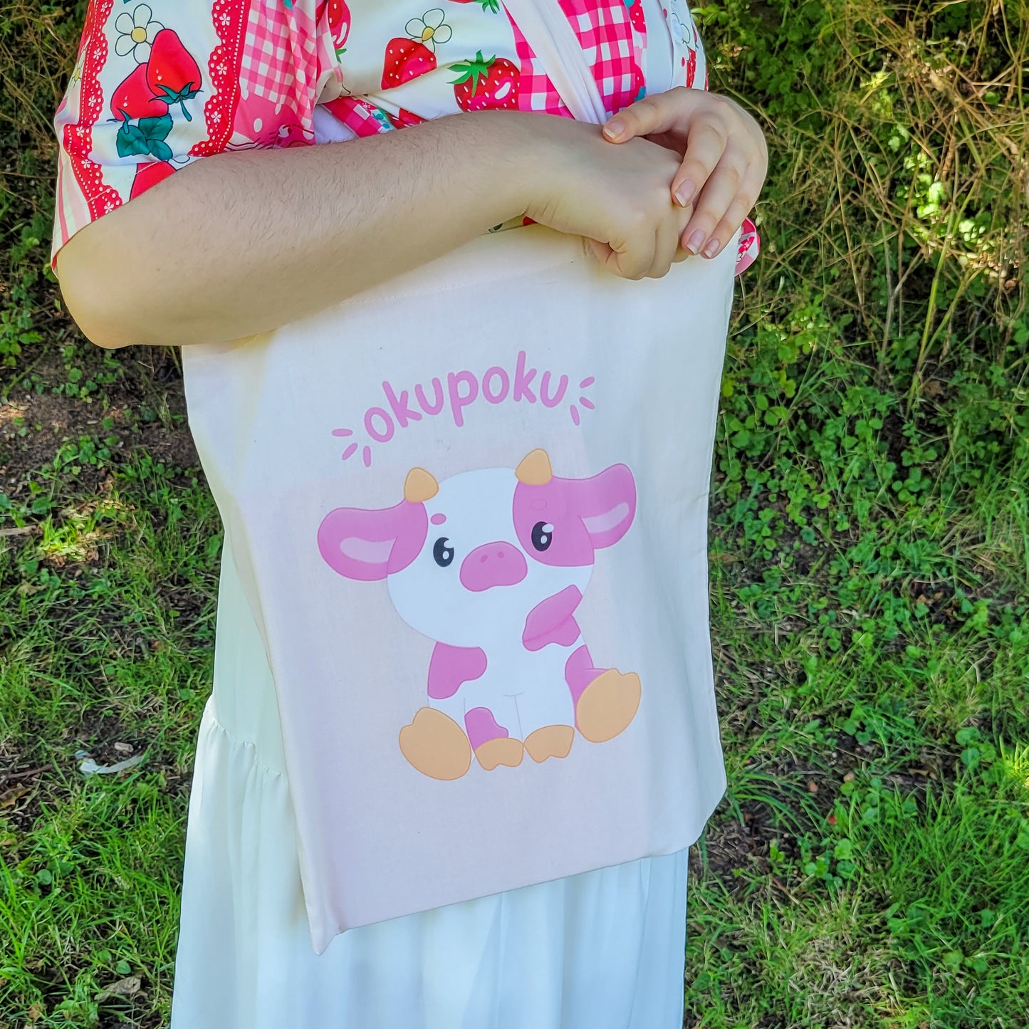 Light pink tote bag featuring an adorable pink cow design and the text okupoku