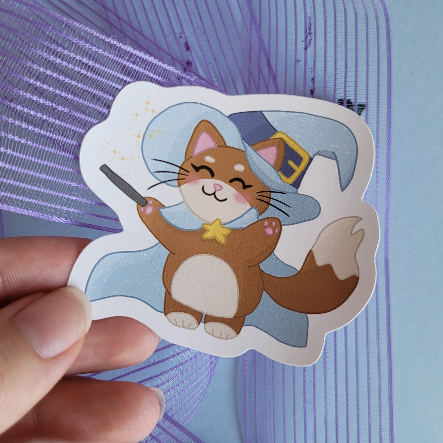 Adorble sticker feautirng a cat dressed a a witch/ wizard