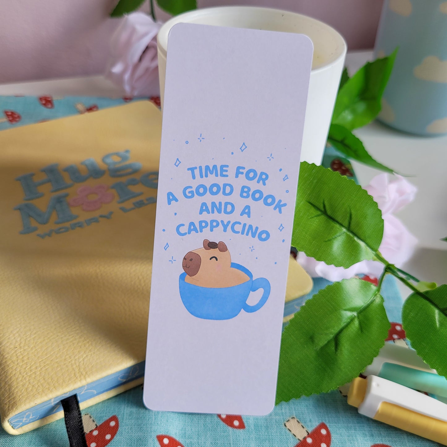 cute bookmark featuring a capybara in a capycino mug and the text: "time for a good book and a capycino"