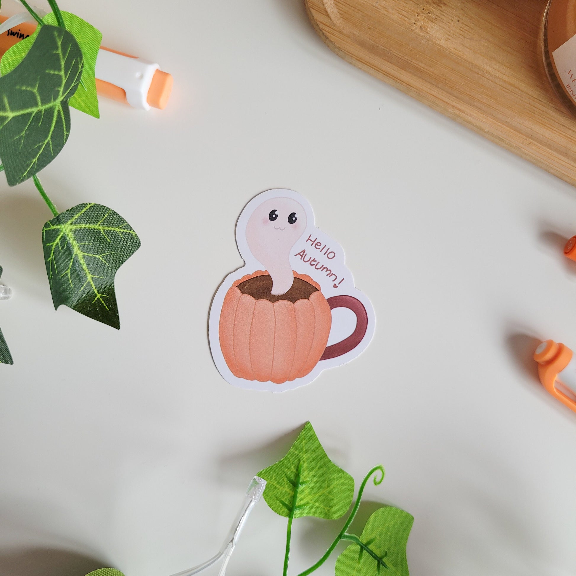 Adorable sticker featuring a friendly ghost coming out of a pumkin latte with the text "Hello Autumn"