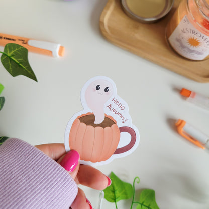 Adorable sticker featuring a friendly ghost coming out of a pumkin latte with the text "Hello Autumn"