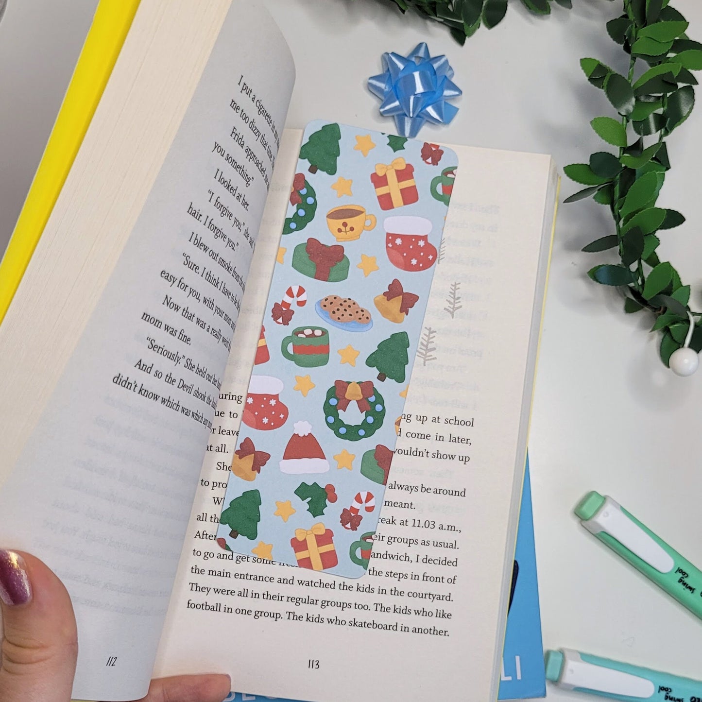 cute christmas themed bookmark featuring a christmas tree, hot chocolate, present, stocking, wreath, santa hat and more