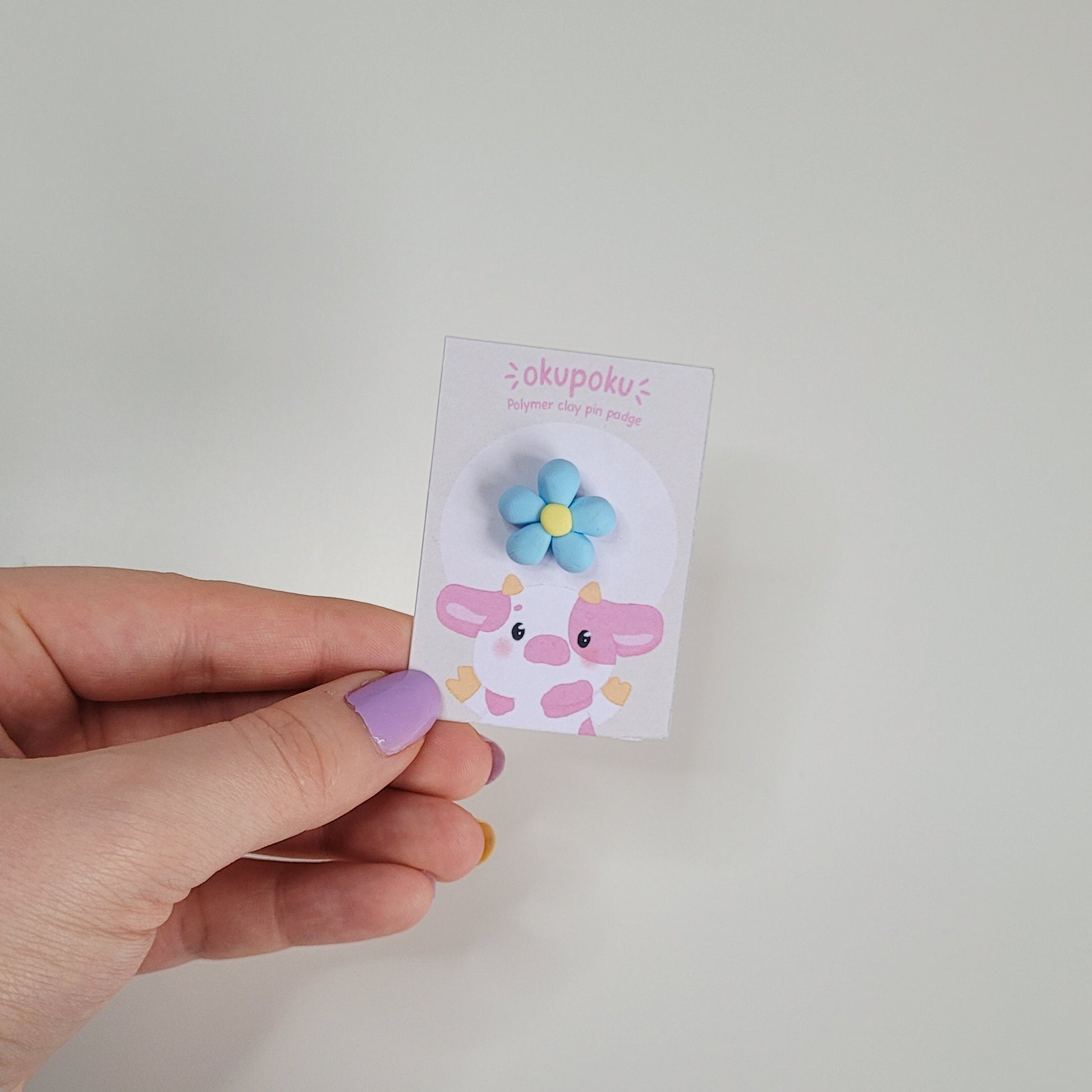 cute handmade blue daisy pin badge made out of polymer clay