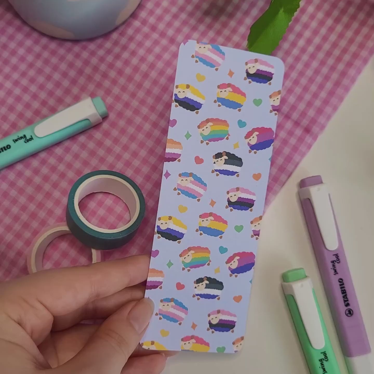 Colourful bookmark featuring a design of sheep with different pride flags on them